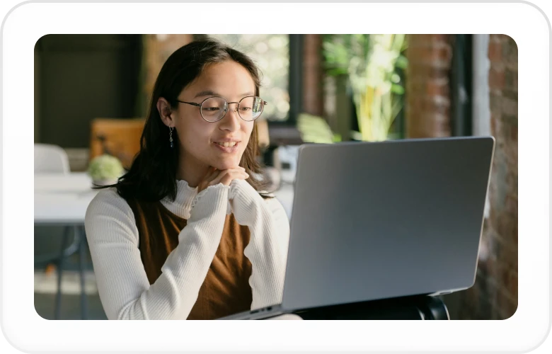 a woman sits at a laptop